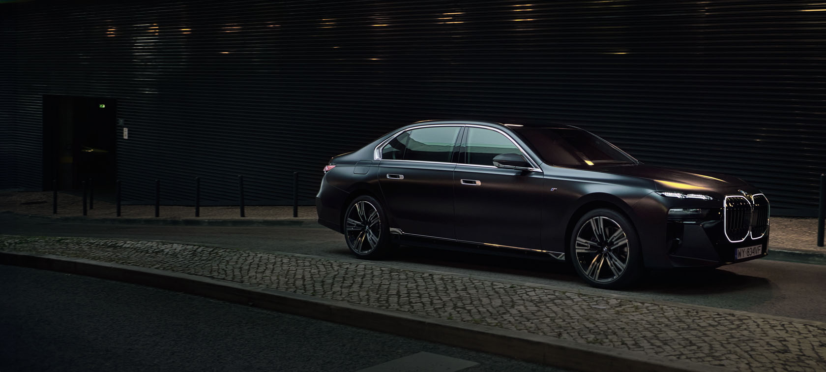 BMW SERII 7 zaparkowane koło budynku